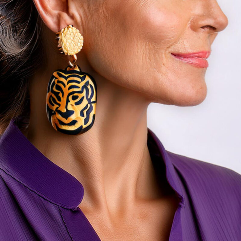 Tiger earrings worn by a lady in a purple shirt